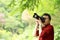 Close up Aisan Chinese man photographer hold camera work in nature shot maple