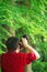 Close up Aisan Chinese man photographer hold camera work in nature shot maple
