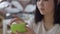Close-up of Aloe facial cream with blurred Asian woman opening jar. Beautiful slim young lady taking care of face skin
