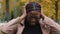 Close-up annoyed african american young woman standing outdoors covering ears with hands from loud noise feeling