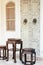 Close up antique chinese traditional chairs and table with white Chino-Portuguese door background. Asia architecture vintage style