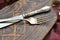 Close up of antique silver fork and knife with aged cutting board with  on wooden background