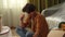 Close up of apartment living room. Man sitting on the floor reading eviction notice papers, looking upset and shocked.