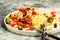 Close-up Appetizing pasta with meat in tomato sauce, vegetables and Parmesan cheese in a large white plate