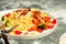 Close-up Appetizing pasta with meat in tomato sauce, vegetables and Parmesan cheese in a large white plate