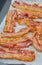 Close-up of appetizing slices of smoked bacon. Isolated on white background.