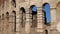 Close-up of arches of Roman Colosseum amphitheater on sunny day on background of clear blue sky. One of most famous