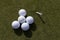 Close-up of an array of white golf balls on green grass