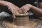 Close-up of an artisan potter's hands carefully sculpting a vase from clay