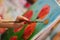 Close up of artist holding brush and painting poppies