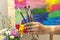 Close up of an artist or painter hands holding dirty paint brushes on colorful picture