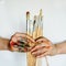 Close Up of an artist/painter hands holding paint brushes