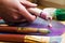 Close-up of the artist\'s hand squeezed from a tube paint on an easel. Brushes, paints, an easel on the table