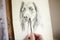 Close Up Of Artist Sitting At Easel Drawing Picture Of Dog In Charcoal