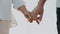 Close-up as white man and a woman in love tenderly holding hands. The concept of family, marriage, tenderness and