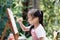 Close up of Asian child girl is painting on the canvas.