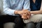 Close-up of Asian couple join hand give to encourage while sitting on the couch in the room to consult mental health problems by d