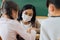 Close-up of Asian female teacher wearing face mask in school building tutoring a primary student children. Elementary