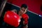 Close up Asian man point red mitt of punch and also look at camera in sport gym. Concept of boxing exercise for good health