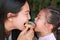 Close up Asian mother and her daughter eating rainbow donut together