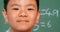 Close-up of Asian schoolboy standing against chalkboard in a classroom at school 4k