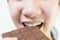 Close up,asian teenage girl eating tasty chocolate bar,deliciously sweet,enjoy the natural taste,smiling young woman holding