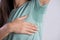 Close-up asian woman with hyperhidrosis sweating. Young asia woman with sweat stain on her clothes against grey background.