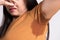 Close-up asian woman with hyperhidrosis sweating. Young asia woman with sweat stain on her clothes against grey background.