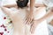 Close up. Asian woman massaging spa with salt. Beauty therapist pouring salt scrub on woman back at health spa