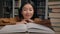 Close-up asian woman student read book in university library smiling girl lady reader enjoy reading novel literature