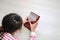 Close-up Asian young hands playing Kalimba Mbira or thumb piano lying on wood floor at home. Rear view