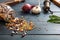 Close up of assortment of legumes in a glass jar, spilled on a wooden tabletop background, pepper grinder, onion, garlic and grate