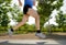 Close up athletic legs of young man running in city park on summer training in healthy lifestyle concept