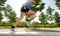 Close up athletic legs of young man running in city park on summer training in healthy lifestyle concept