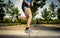 Close up athletic legs of young man running in city park with trees on summer training session practicing sport healthy lifestyle