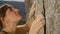 CLOSE UP: Athletic woman grips a crack with chalked up hands while rock climbing