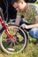 Close up of attractive adult man, Handsome Bike Mechanic pumping up bicycle wheel World Bicycle Day