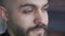 Close-up of attractive brunette man with beard and mustaches looking away smiling. Handsome man indoors