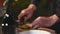 Close up attractive handsome Asian male bartender hand in black formal suit slicing lemon for making cocktail as entertainer in