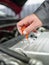 Close-up of an auto mechanic examines the oil in the car