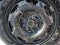 Close-up of an automobile wheel. Small prickly dirty icicles hang from the wheel. The texture of the snow on the car. Iron cover.