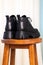 Close-up back side of black elegant shoes on wooden background. Leather winter boots, stylish lady footwear concept