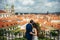 The close-up back view of the hugging newlyweds enjoying the view of the Prague during the cloudy weather.