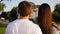 Close up of the back view of nice attractive young couple walking the park. Rear. Outdoor.