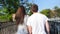 Close up of the back view of nice attractive young couple walking the park. Rear. Outdoor. Medium shot.