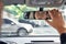 Close up back view portrait of man in specs adjusting rearview mirror while sitting in his car, selective focus