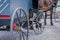 Close up of back view of wheel of Amish buggy with a legs horse parked in a farm