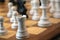 Close-up of back and white chess pieces, wooden board