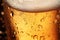Close up of a backlit glass of delicious golden beer covered with water drops. Bar background