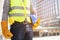 Close up backside view of engineering male construction worker stand holding safety yellow helmet